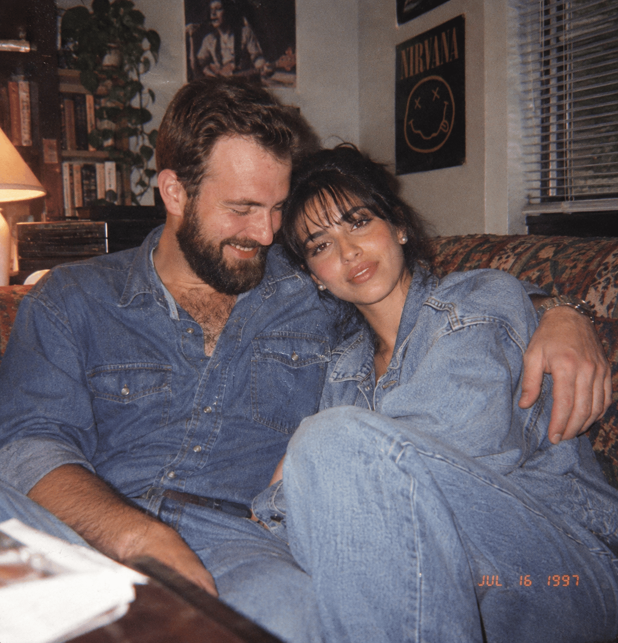 1990s couple photograph in casual denim with direct flash, 35mm grain and background clutter
